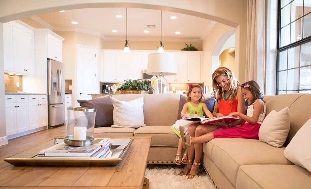 Mom reading to kids on a couch in a living room.