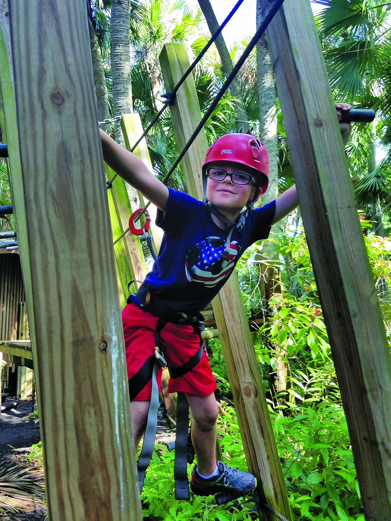 A boy navigates the Chutes & Ladders maze in Treetop Trek at Brevard Zoo | Viera FL